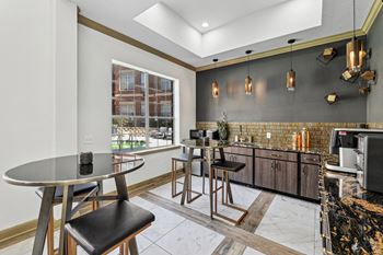 A modern kitchen with a round table and bar stools.